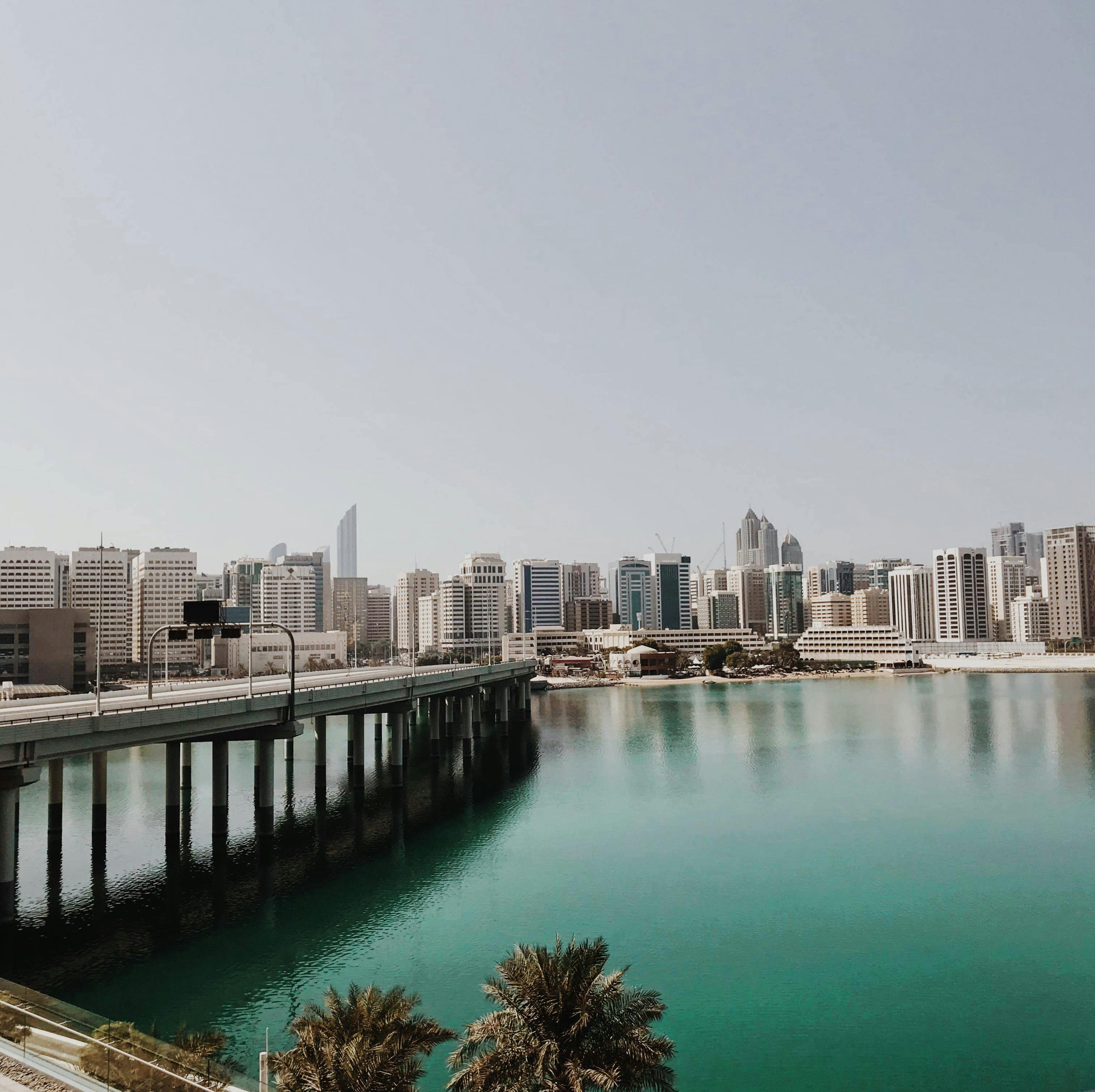 A stunning view of Abu Dhabi's skyline, showcasing modern architecture and vibrant city life against a clear blue sky.