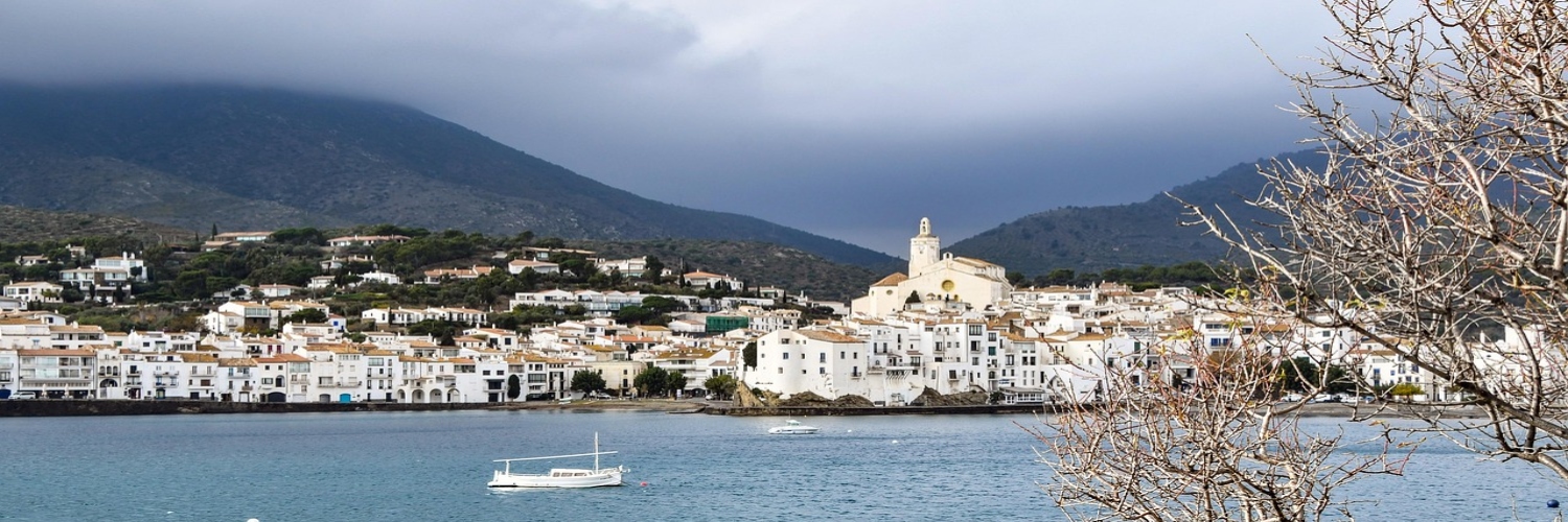 A coastal town in Catalonia with boats floating in the water, showcasing a picturesque sightseeing view.