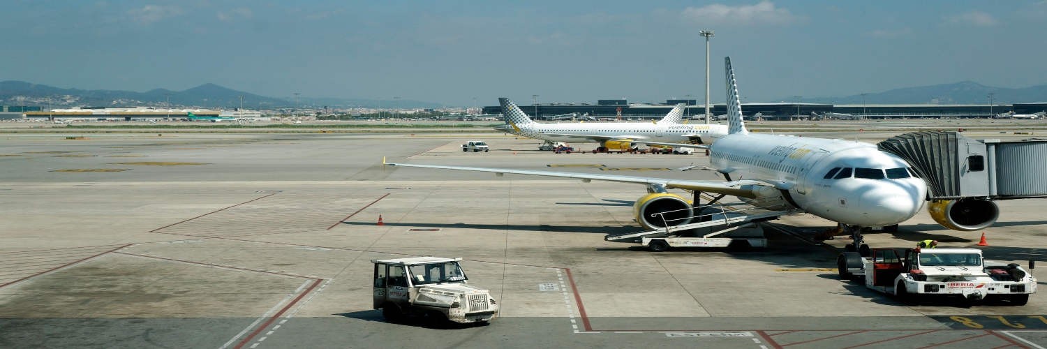 A white and yellow aircraft on the tarmac, located at Girona Airport.