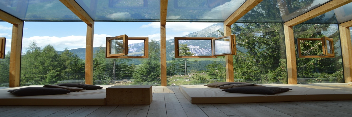 A hotel room featuring large windows that showcase a stunning view of the mountains in Canberra.