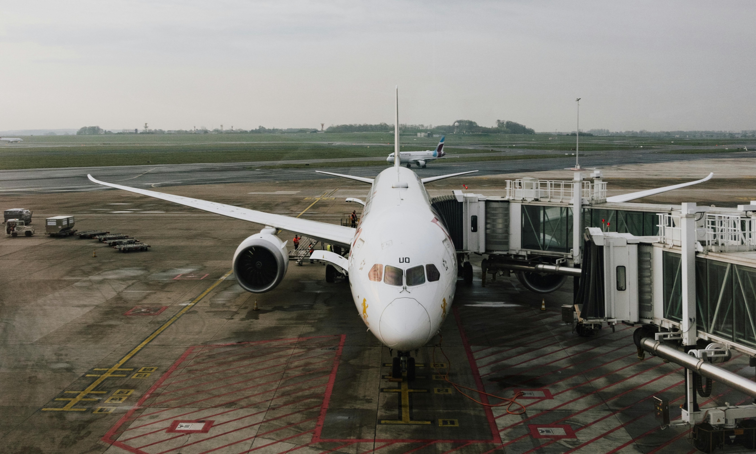 An airplane parked at a terminal at Paris Airport, ready for passengers to board.
