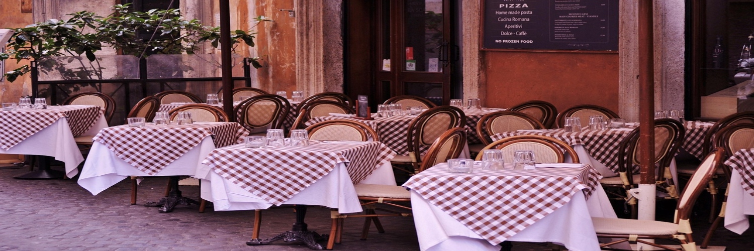 A Parisian restaurant with outdoor seating, showcasing tables and chairs arranged for al fresco dining.