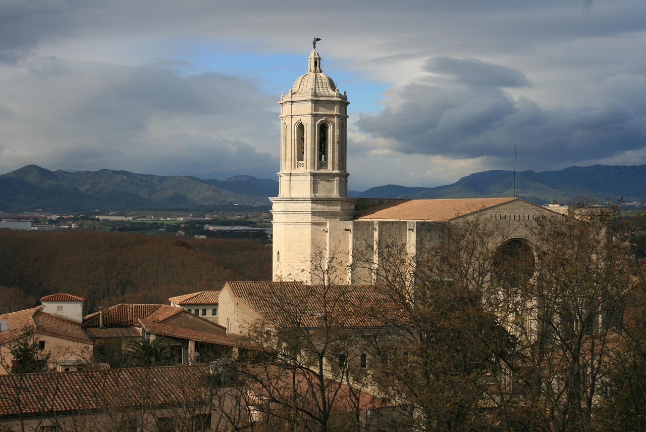 Girona Cathedral, a large structure with an impressive clock tower, stands majestically.