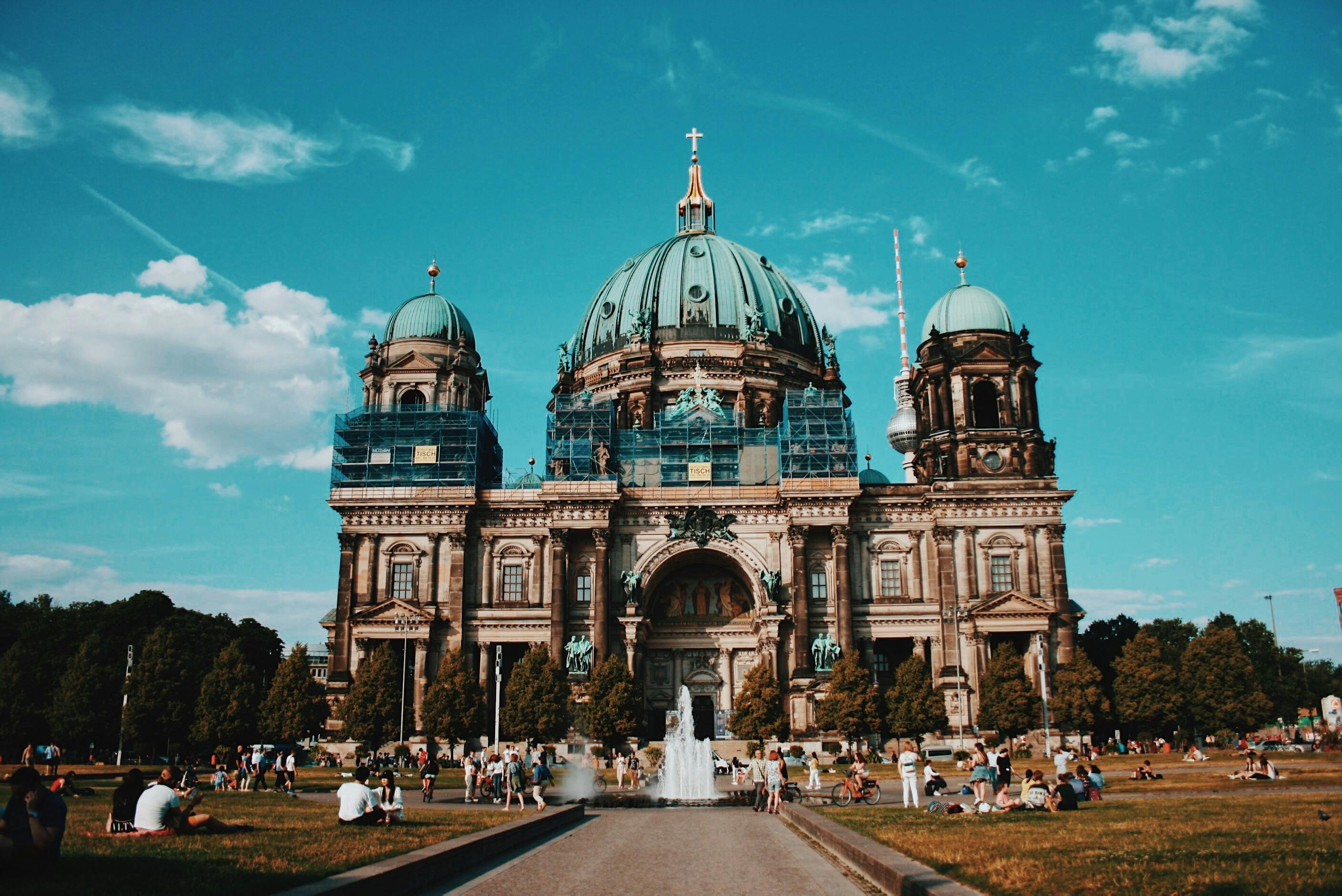 Berlin Cathedral features a large structure with prominent brown and blue domes, showcasing its architectural grandeur.
