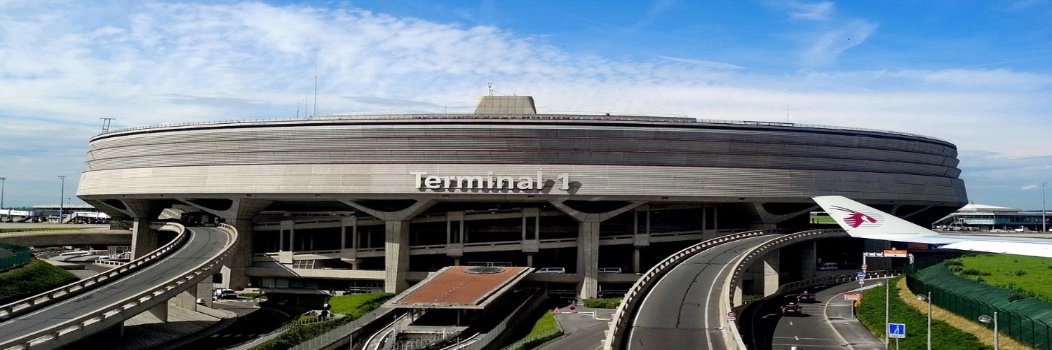 An airplane parked in front of a large building, illustrating the taxi fare route from Charles de Gaulle Airport to the Eiffel Tower.