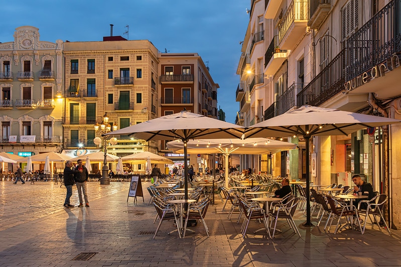 A city square featuring a prominent clock tower, showcasing stunning architecture in Reus.