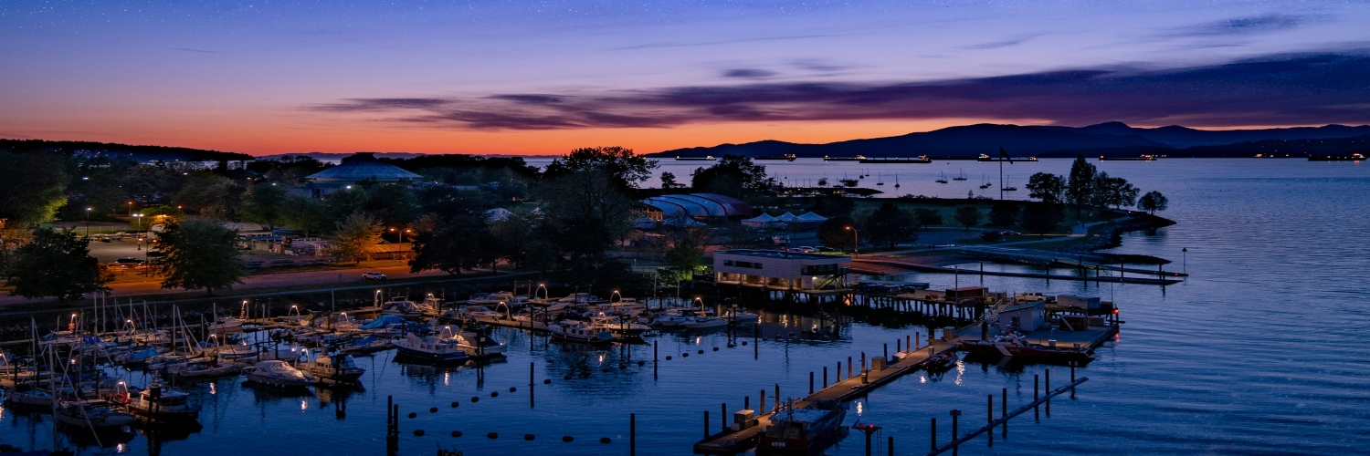 A tranquil marina at dusk, featuring several boats docked against a colorful sky, highlighting Vancouver's scenic beauty.