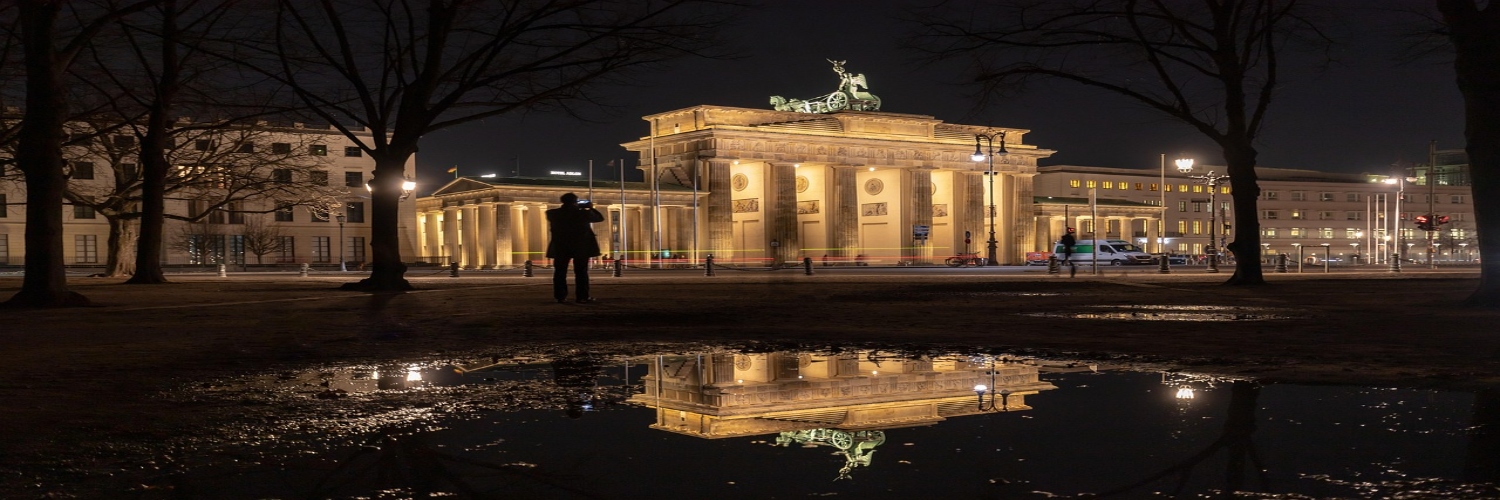 Brandenburg Gate illuminated at night, showcasing its iconic neoclassical architecture against a dark sky in Berlin.