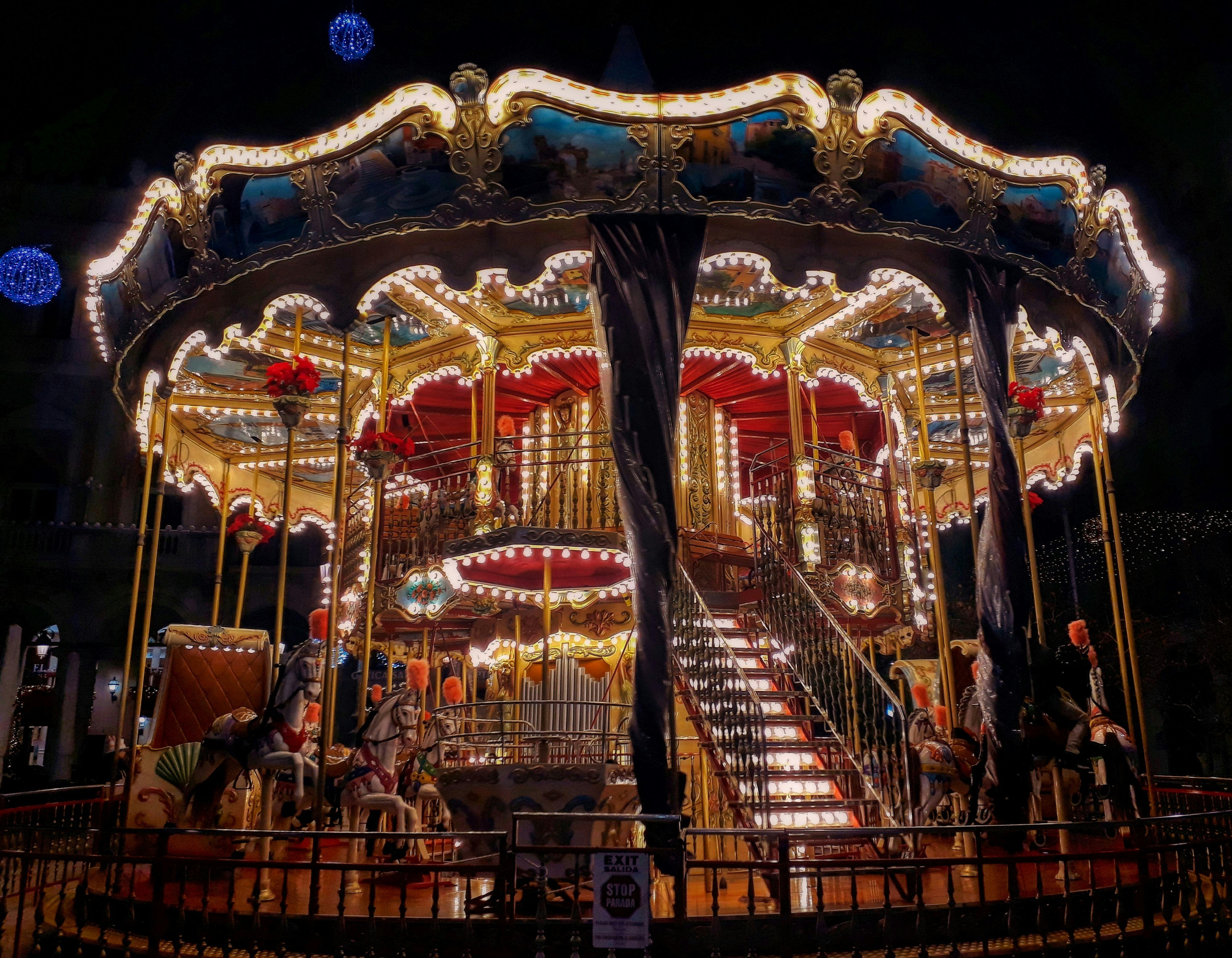 A brightly lit carousel at night in an amusement park in Reus, showcasing colorful lights and festive atmosphere.