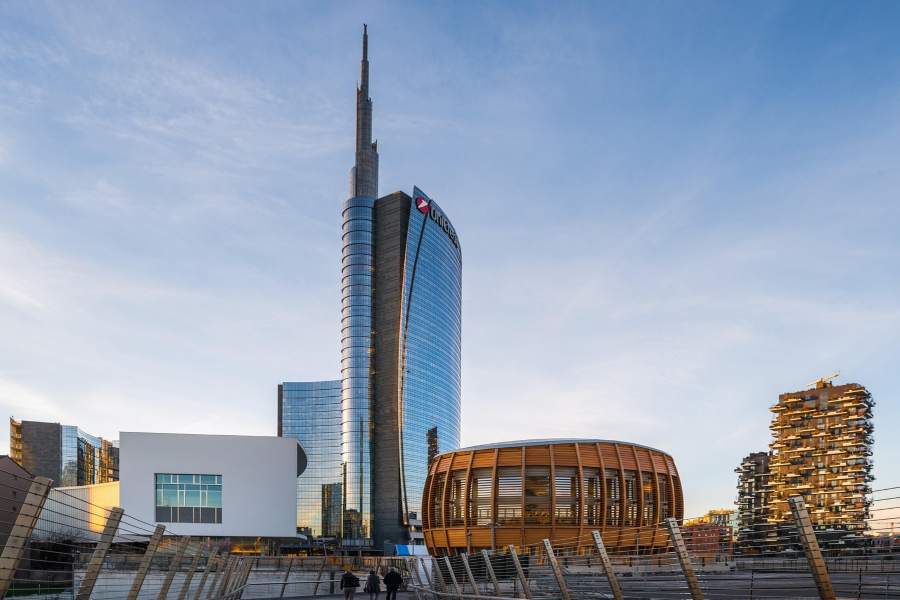 A slender skyscraper is adjacent to a broad building, showcasing Milan's urban scenery.