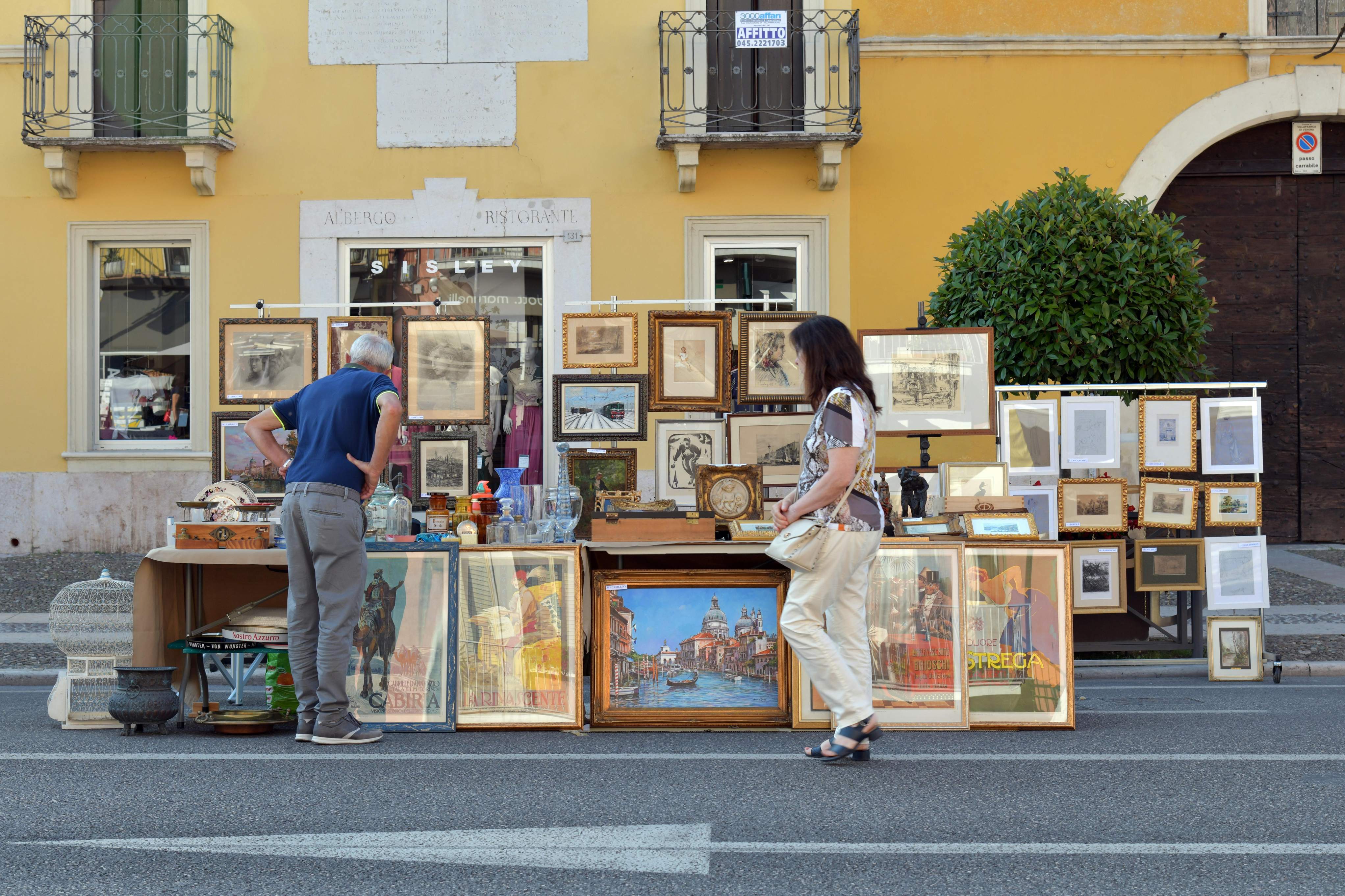 In Villafranca di Verona, Veneto, Italy, a man and woman are positioned in front of a table, appearing to discuss something.
