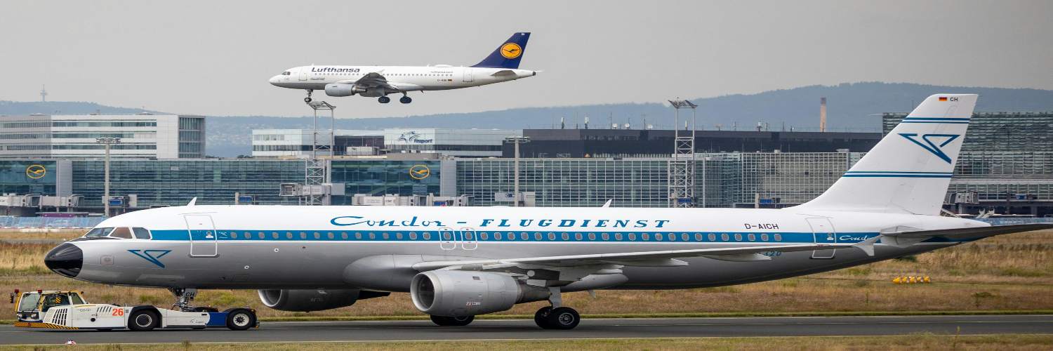 A large jetliner on the runway with Frankfurt Airport Terminal 1 visible in the background.