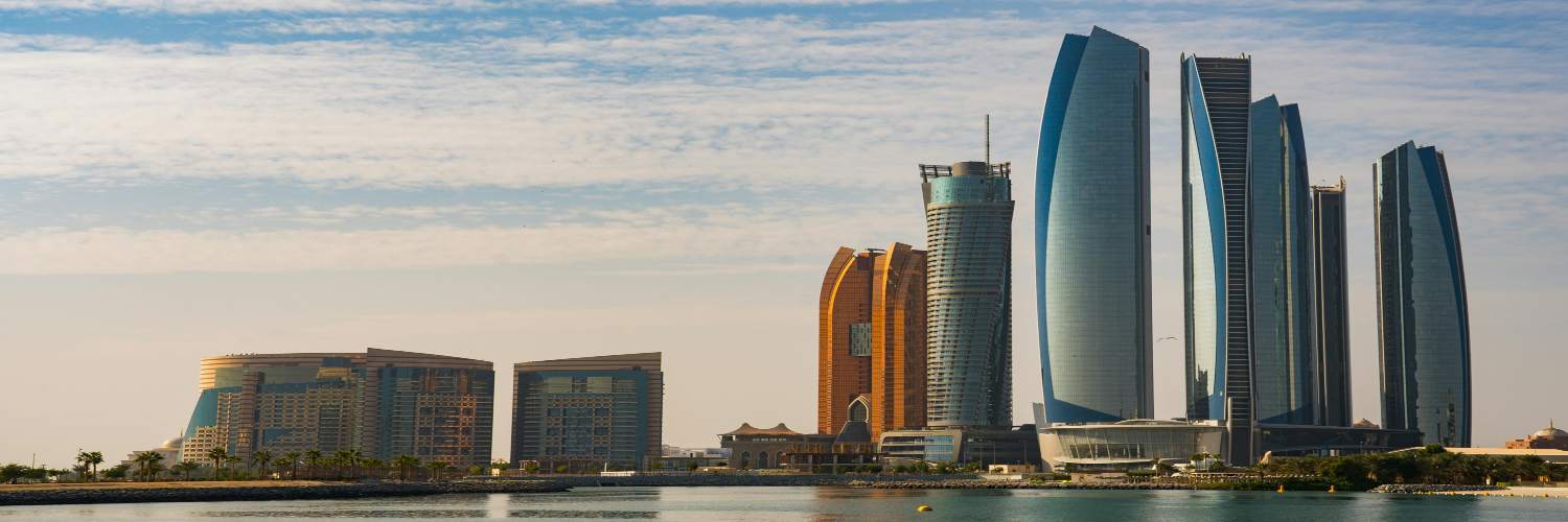 Skyline of Abu Dhabi featuring tall modern buildings against a clear blue sky.