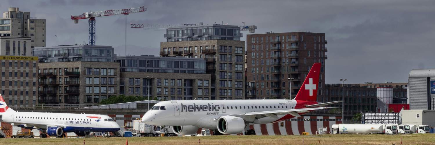Two Swiss Air aircraft stationed on the tarmac near a terminal at London City Airport.