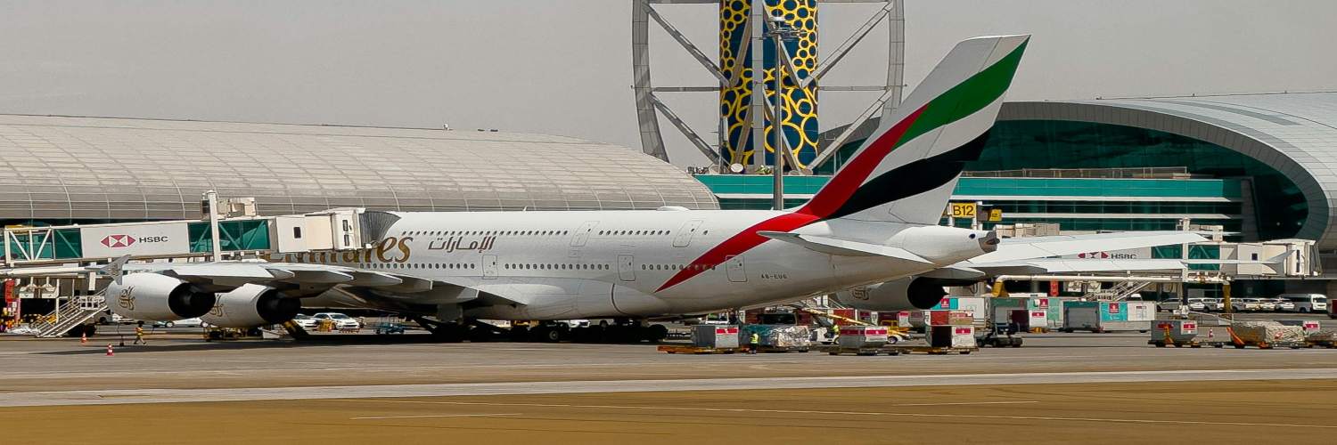 Emirates airplane parked at Dubai airport, ready for passenger transfers and flights.