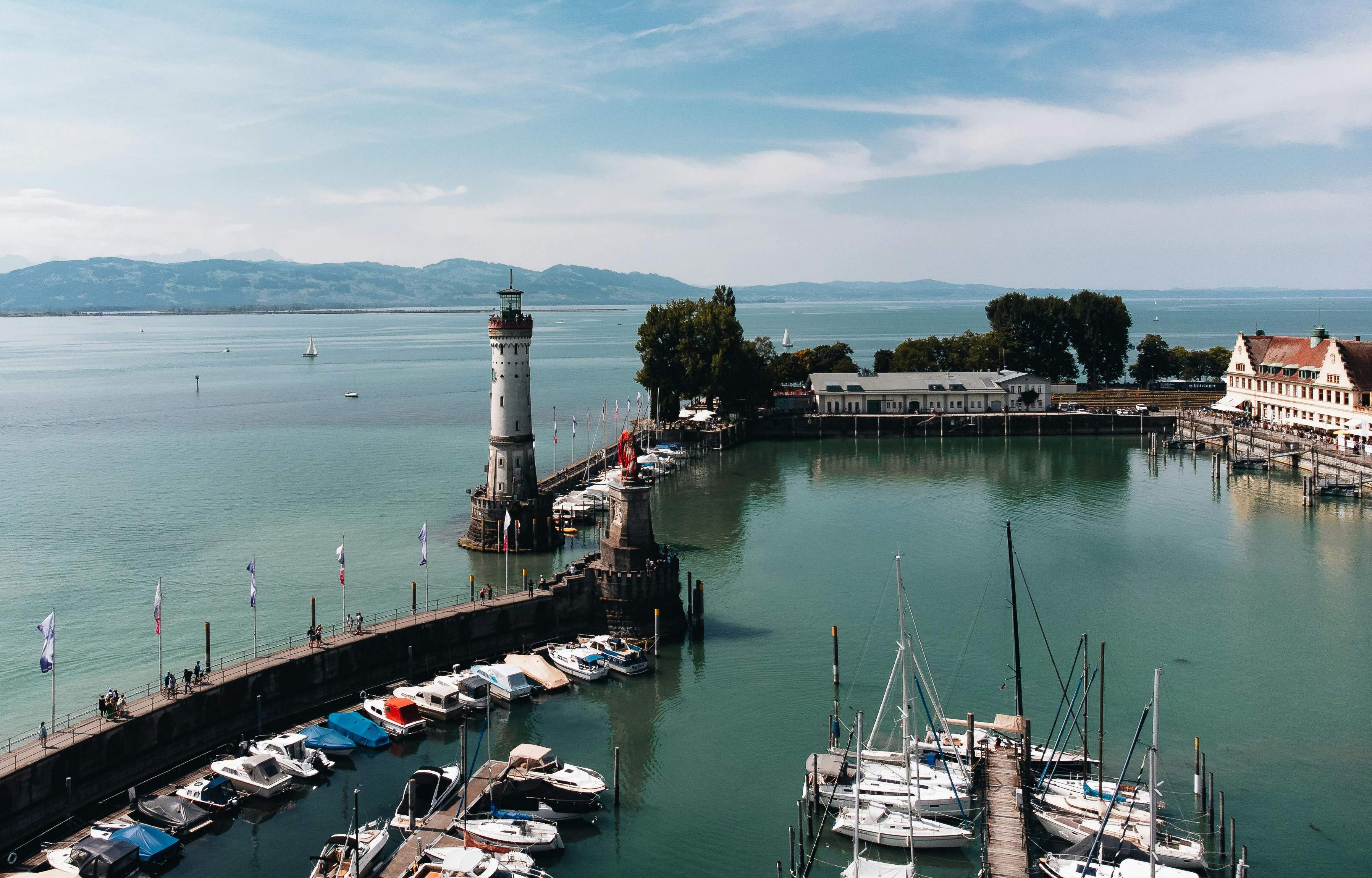 Boats are docked in a tranquil harbor at Bodensee, Germany, surrounded by picturesque scenery.
