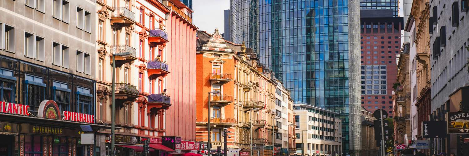 A vibrant street in Frankfurt with towering buildings and pedestrians walking, capturing the essence of city life.