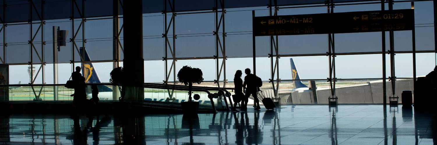 People’s silhouettes moving through the Frankfurt airport terminal, highlighting the hustle and bustle of air travel.
