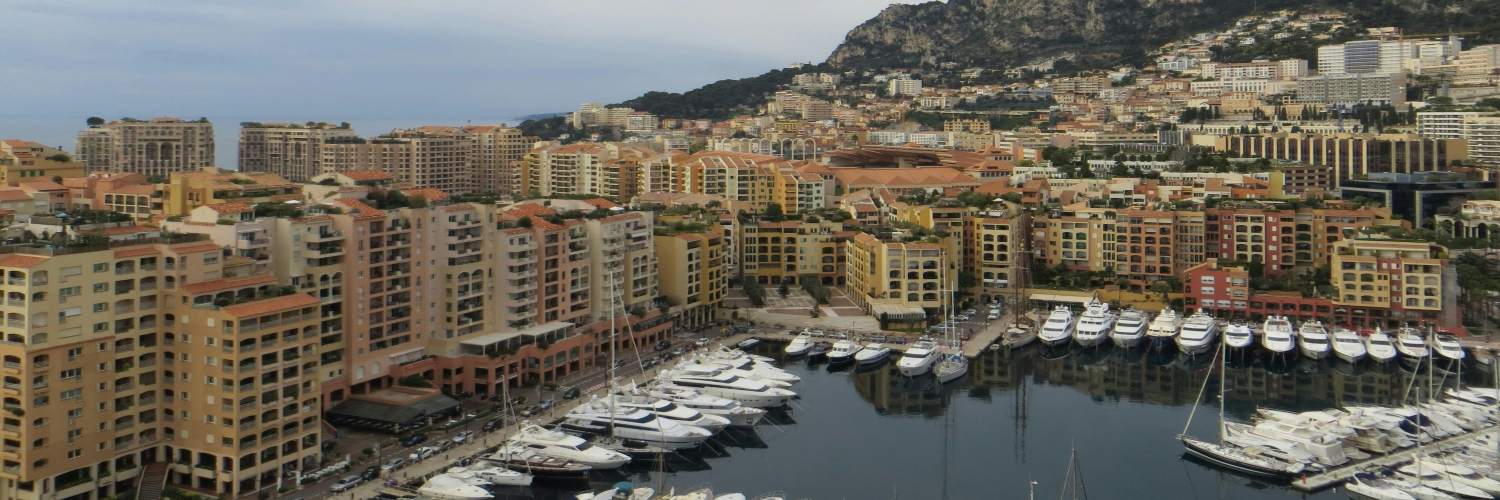 Aerial view of Monaco showcasing the cityscape and harbor with boats, highlighting its coastal beauty.