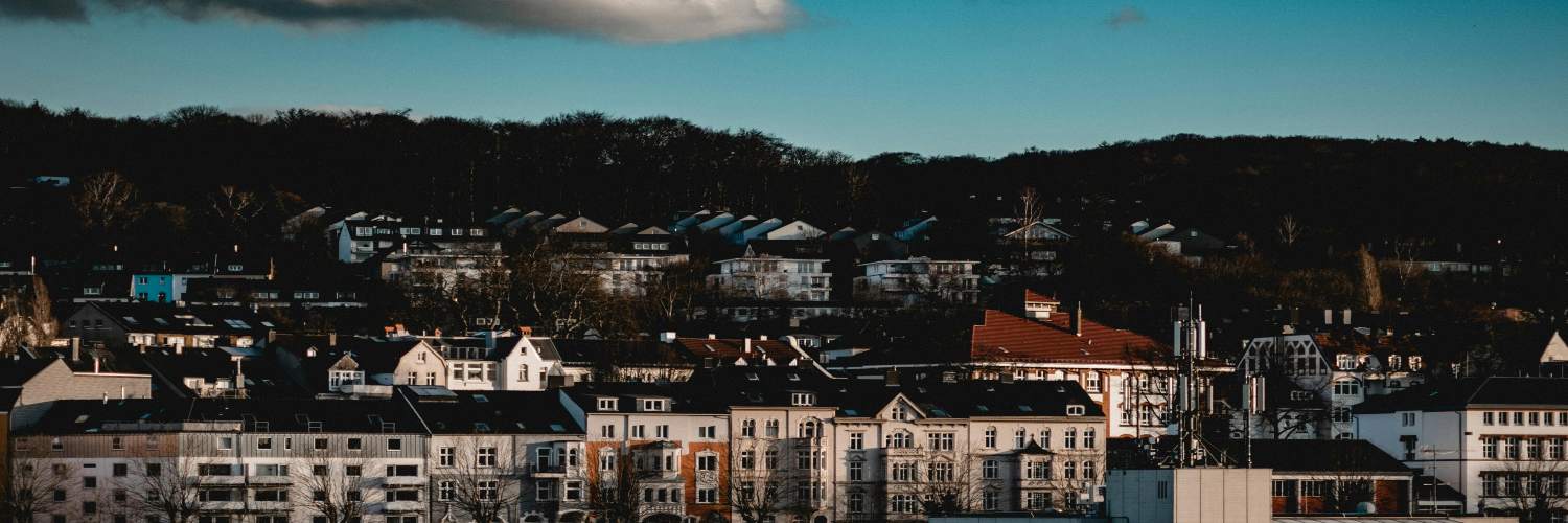 Urban skyline of Wuppertal, Germany, featuring numerous buildings under a cloudy sky.