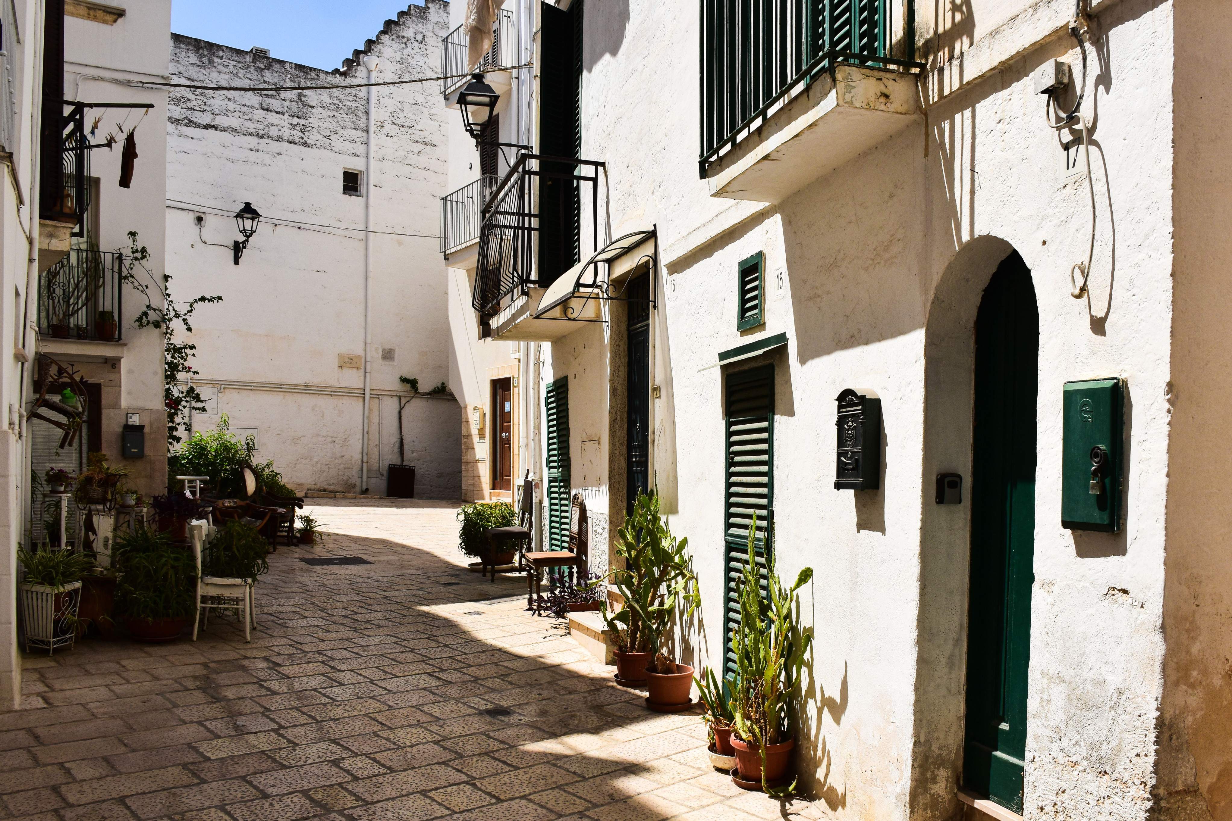 A quaint narrow street in Bari, adorned with buildings and vibrant plants, reflecting the city's unique character.