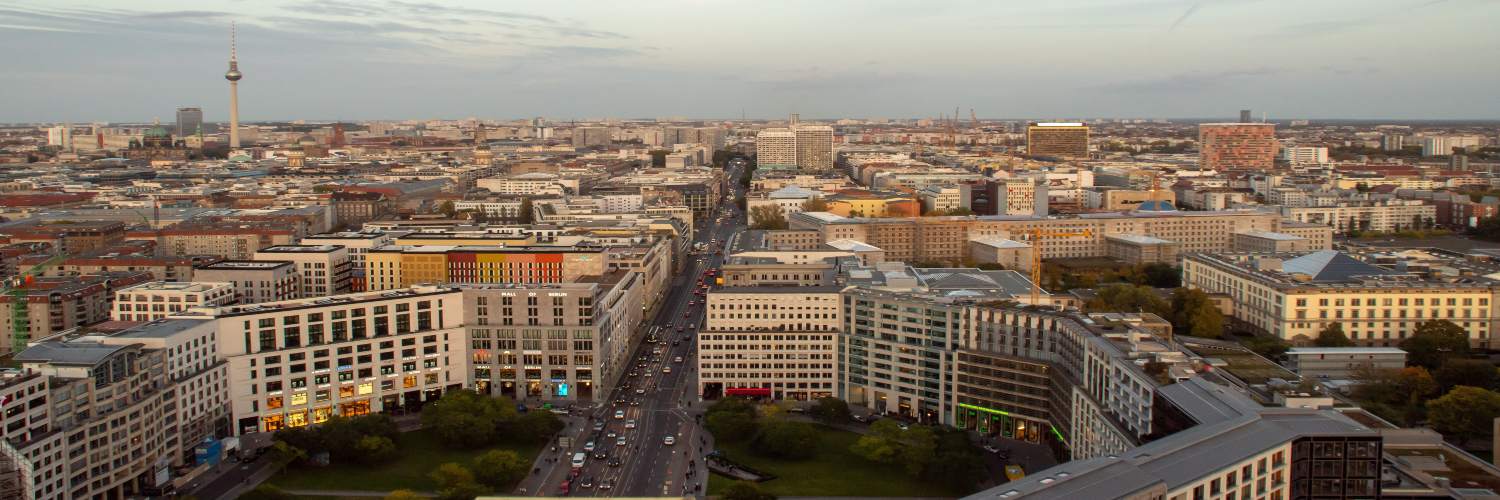 Panoramic aerial view of Berlin city skyline featuring the Berlin TV Tower and urban cityscape.