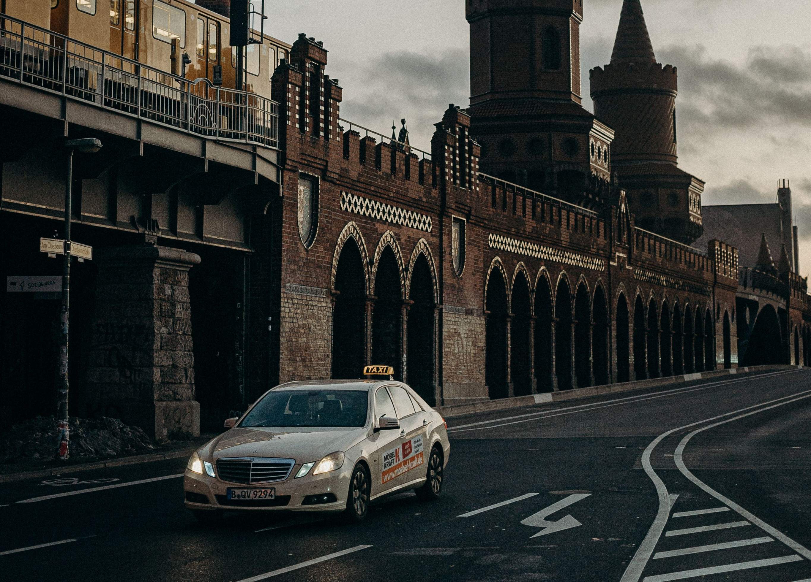 A Berlin taxi navigating a street, with a clock tower visible in the background, showcasing urban transportation.