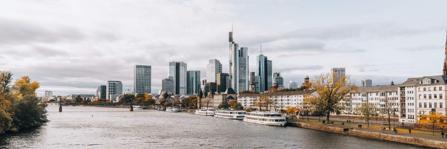 Frankfurt's skyline featuring modern skyscrapers against a backdrop of autumn foliage.