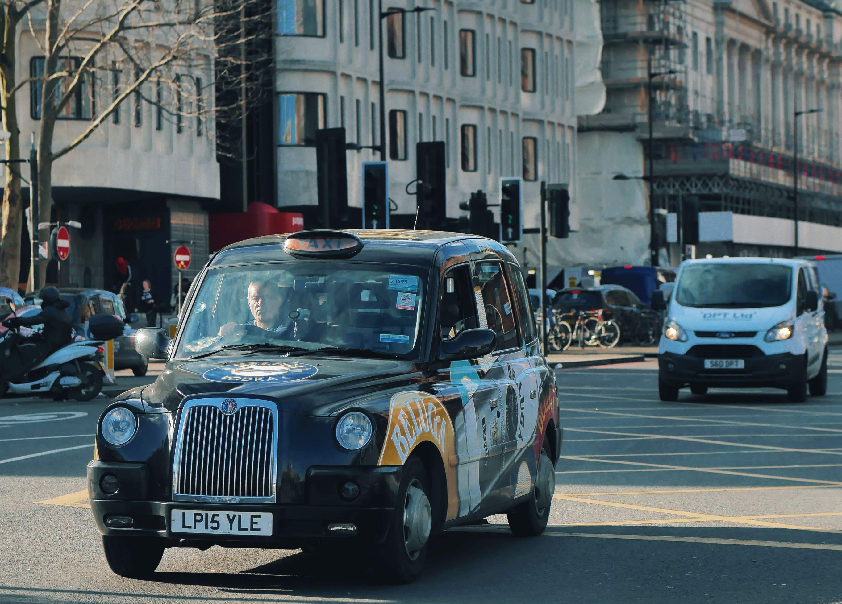 A row of parked cars lined along a cobblestone street in London, showcasing urban architecture and city life.