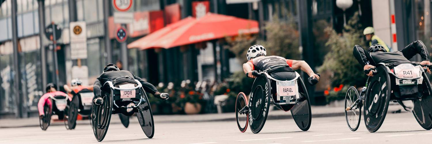 A group of athletes riding bicycles together on a bustling street in Berlin, showcasing urban cycling culture.