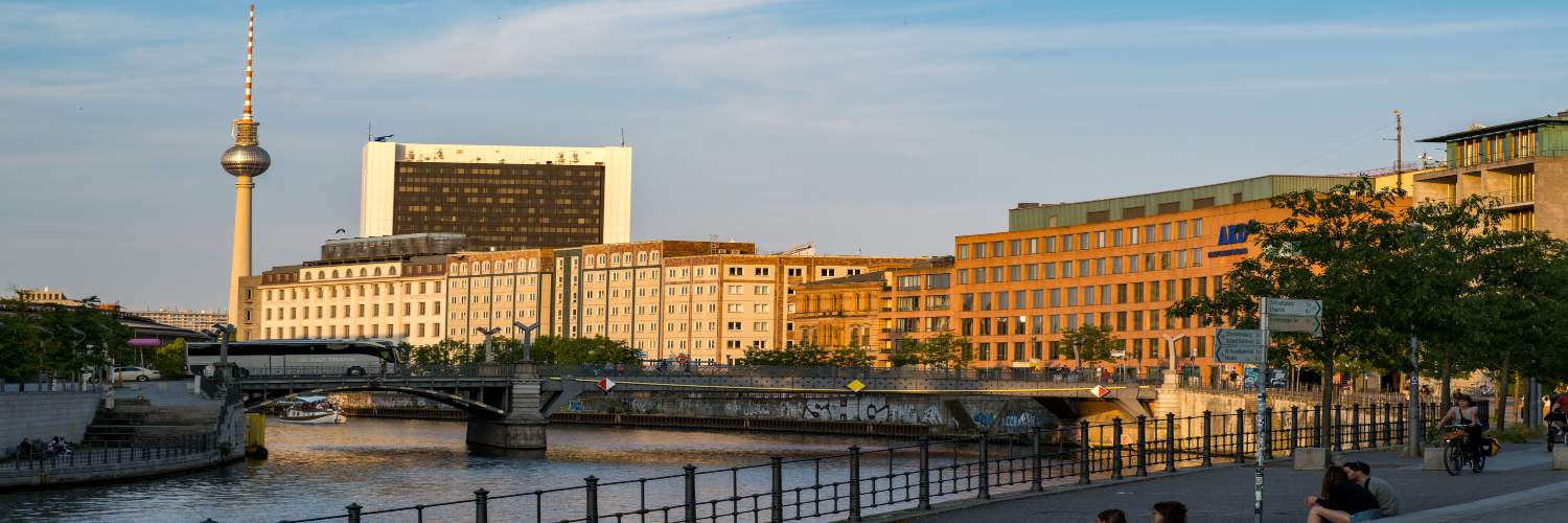 Berlin skyline featuring the iconic television tower above the Spree River, showcasing urban architecture and waterways.