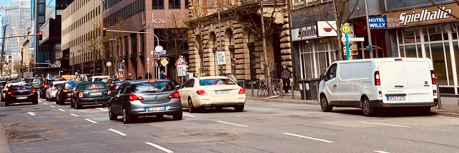 Cars navigate a bustling street in Frankfurt, showcasing the city's vibrant urban traffic and car services.
