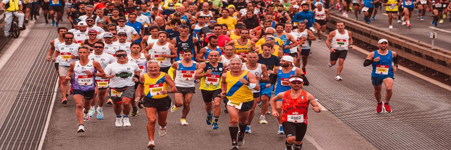 A group of runners participating in the London Marathon, moving along a city street lined with spectators.